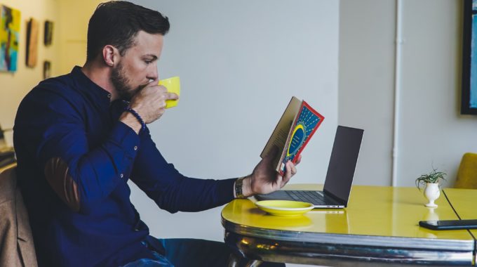 coactiv consulting Mann liest ein Buch und trinkt aus einer Tasse